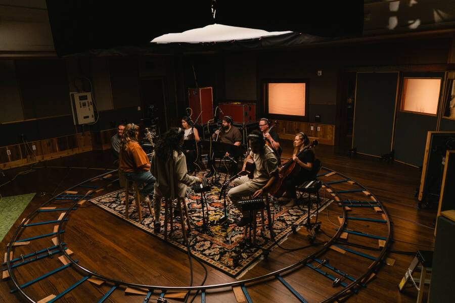 A band sits in the Live Room at the Church Studio, surrounded by a track for a camera dolly.